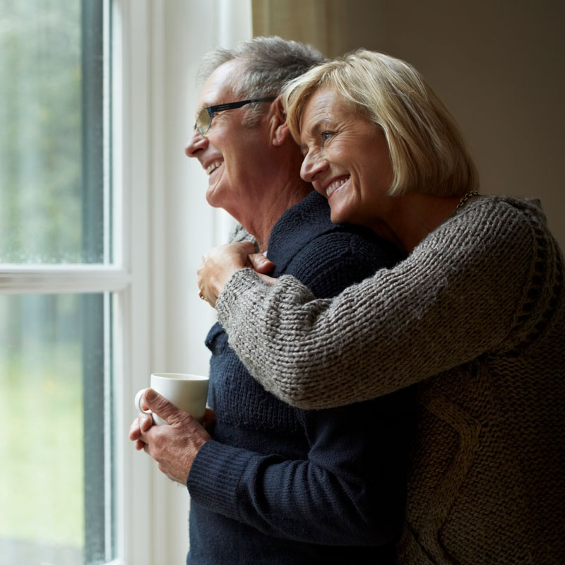 elderly couple looking out window